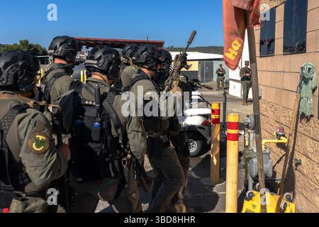 Membri del team di reazione speciale del corpo dei Marines degli Stati Uniti con il Provost Marshal Office, Marine Corps installations West, Marine Corps base Camp Pendleton, stack durante un evento sparatutto attivo simulato a MCB Camp Pendleton, California, 20 maggio 2025. Semper Durus è un'esercitazione di interoperabilità e addestramento di comando regionale su vasta scala MCIWEST progettata per migliorare la preparazione alle emergenze e le capacità di risposta rapida in più installazioni di corpi dei Marines nel sud-ovest degli Stati Uniti. Foto Stock