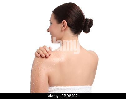 Donna che applica il body scrub sulla spalla su sfondo bianco Foto Stock