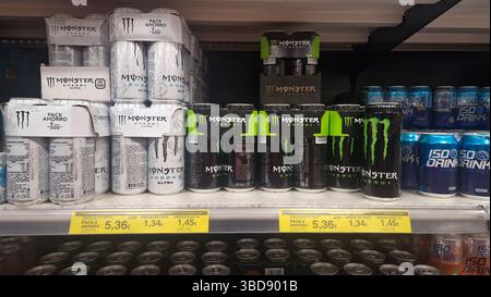 Barattoli in alluminio di Monster Energy drink sullo scaffale del negozio, attenzione selettiva. Foto Stock