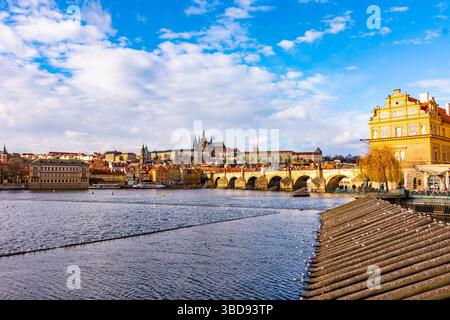 Praga, repubblica Ceca: Guarda il ponte Carlo e il castello di Praga in lontano. Soleggiata giornata invernale vicino al fiume Moldava. Vista panoramica della città di Praga, Citysca Foto Stock