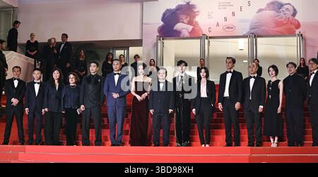 Cannes, Francia. 22 maggio 2025. Il regista Bi Gan (C) arriva con i membri del cast sul Red carpet prima della prima del film "Resurrection" durante la 78a edizione del Festival di Cannes a Cannes, Francia meridionale, il 22 maggio 2025. La 78esima edizione del Festival di Cannes ha preso il via a Cannes il 13 maggio, con il film cinese "Resurrection" diretto da Bi Gan in competizione per il più alto onore del festival, la Palme d'Or insieme ad altri 21 film. Crediti: Gao Jing/Xinhua/Alamy Live News Foto Stock