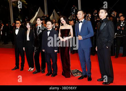 Cannes, Francia. 22 maggio 2025. Il regista Bi Gan (C) arriva con i membri del cast sul Red carpet prima della prima del film "Resurrection" durante la 78a edizione del Festival di Cannes a Cannes, Francia meridionale, il 22 maggio 2025. La 78esima edizione del Festival di Cannes ha preso il via a Cannes il 13 maggio, con il film cinese "Resurrection" diretto da Bi Gan in competizione per il più alto onore del festival, la Palme d'Or insieme ad altri 21 film. Crediti: Gao Jing/Xinhua/Alamy Live News Foto Stock