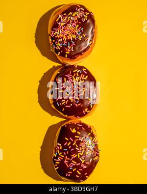 Ciambelle Boston crema su sfondo giallo Foto Stock