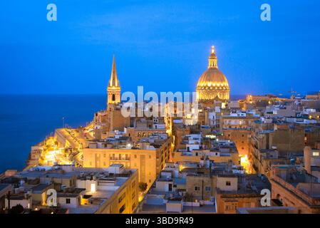 Paesaggio urbano di la Valletta Malta, vista notturna dello storico skyline della città vecchia di la Valletta che mostra la cupola illuminata della basilica carmelitana di Malta Foto Stock
