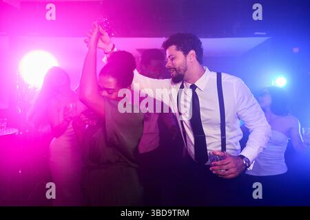 I manager si godono un drink e ballano alla festa del nightclub Foto Stock