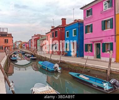 Venezia, Italia - 10 gennaio 2017: Ponte dell'arco sul canale d'acqua calmo e case colorate sull'isola di Burano nel pomeriggio invernale. Foto Stock