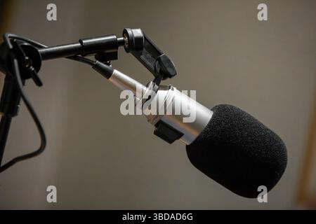 Un microfono professionale è installato in uno studio audio, progettato per registrazioni di alta qualità. L'ambiente è calmo e concentrato, ideale per musica o voce Foto Stock