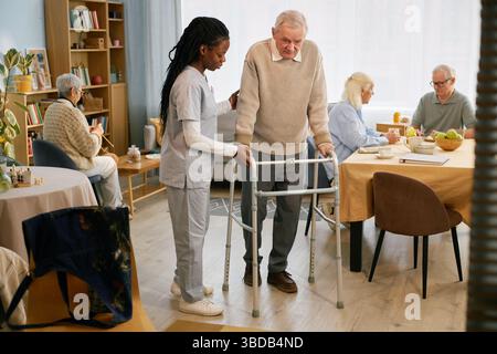 Assistenza agli anziani tramite Walker nel Senior Care Center Foto Stock