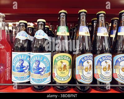 Bottiglie di birra assortite sullo scaffale del supermercato esposte nel corridoio del negozio. Foto Stock