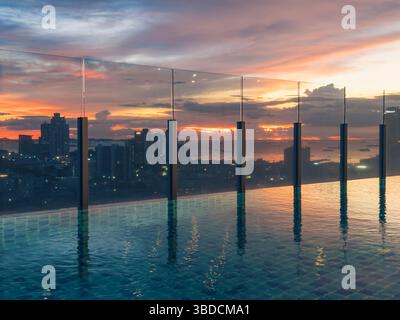 Splendida vista del tramonto sullo skyline della città da una piscina sul tetto durante le ore al crepuscolo Foto Stock