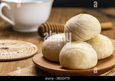 Vista closeup della pasticceria cinese fatta in casa o torta di luna riempito con pasta di fagioli mungo dolce e tuorlo d'uovo salato in un piatto di legno posto su sackcloth con WI Foto Stock