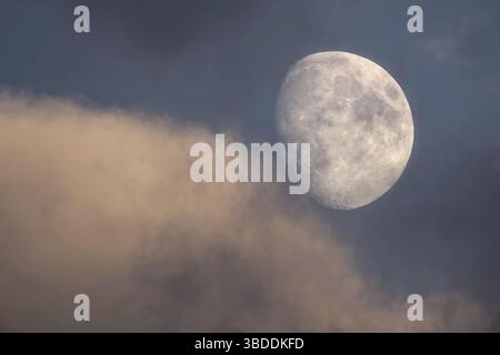 Tre quarti di luna con nuvole serali Foto Stock