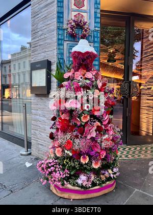 Londra, Chelsea in Bloom 2025 esposizione floreale. Manichino femminile ricoperto di fiori rossi e rosa per creare un abito. Rose, Gerber Daisies, Flamingo Lily. Foto Stock