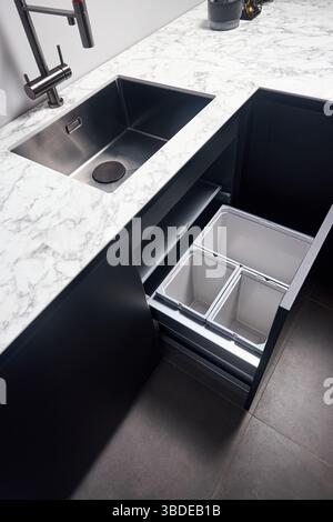 Armadietto cestino cucina. Cassetto cucina estraibile per cassettiera raccolta differenziata sotto il lavabo quadrato e rubinetto laminato ad alta pressione H. Foto Stock