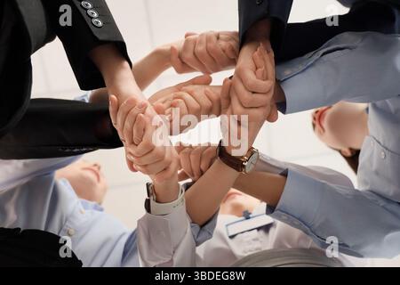 Uomini d'affari che stringono la mano dopo le negoziazioni in ufficio, vista dal basso Foto Stock
