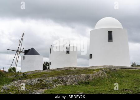Evora, Portogallo - 24 marzo 2022: I mulini a vento di Sao Bento di Evora sotto un cielo sovrasparato espressivo Foto Stock