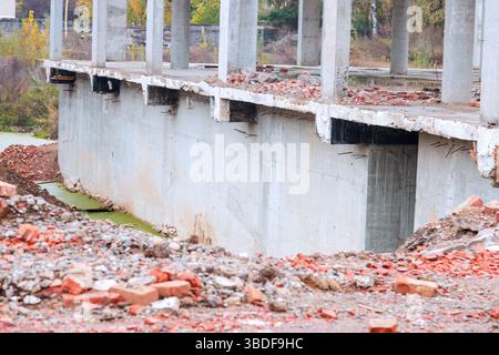 Rivela grandi strutture in calcestruzzo in fase di demolizione i detriti circostanti includono mattoni macerie, creando un'atmosfera desolata. Foto Stock
