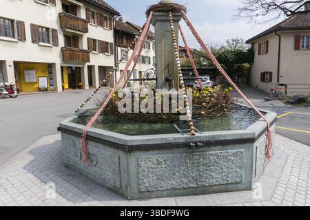 Una vista dettagliata di una festosa decorazioni per vacanze di Pasqua sul villaggio fontane della piccola città di Maienfeld nelle Alpi Svizzere Foto Stock
