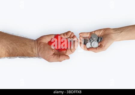 Mano dell'uomo con monete per mano della donna con cuori rossi su sfondo bianco, isolata. Concetto di amore e denaro Foto Stock