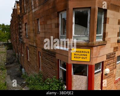 Port Glasgow, Inverclyde, Scozia, Regno Unito. 24 maggio 2025. Vista di un complesso residenziale condannato a Clune Park, che ora è in fase di demolizione per consentire la riqualificazione. Il consiglio locale ha acquistato proprietà decrepite dai proprietari per molti anni per consentire la demolizione. Una chiesa e una scuola elementare sono già state demolite lasciando quindici appartamenti da demolire. Iain Masterton/Alamy Live News Foto Stock