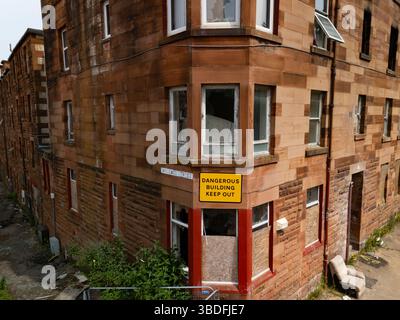 Port Glasgow, Inverclyde, Scozia, Regno Unito. 24 maggio 2025. Vista di un complesso residenziale condannato a Clune Park, che ora è in fase di demolizione per consentire la riqualificazione. Il consiglio locale ha acquistato proprietà decrepite dai proprietari per molti anni per consentire la demolizione. Una chiesa e una scuola elementare sono già state demolite lasciando quindici appartamenti da demolire. Iain Masterton/Alamy Live News Foto Stock