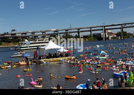 The Big Float, Portland, Oregon - 14 luglio 2018: Le persone galleggiano sul fiume Willamette con gonfiabili, ascoltando musica dal vivo su un palco galleggiante. Foto Stock