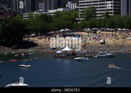 The Big Float, Portland, Oregon - 14 luglio 2018: Le persone si riuniscono sulla spiaggia e in acqua con carri galleggianti e barche per un evento estivo. Foto Stock