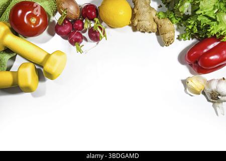 Manubri, verdure e lattuga, concetto di fitness per una dieta dimagrante vegetariana sana ed esercizio sportivo, vista dall'alto su uno sfondo bianco Foto Stock