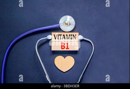 Simbolo della vitamina B1. Parole concettuali vitamina B1 su bellissimi blocchi di legno. Cuore in legno e stetoscopio. Splendido sfondo nero. Vita medica sana Foto Stock