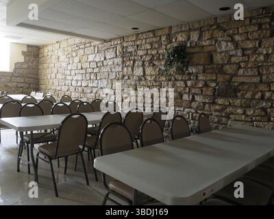 Sedie e tavoli in una sala vuota illuminata da luce naturale Foto Stock