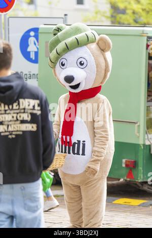 Persona travestita in costume da orso con sciarpa rossa su una strada trafficata, Sindelfingen, distretto di Boeblingen, Germania, Europa Foto Stock
