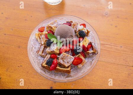 Deliziosi waffle con gelato al cioccolato e frutti di bosco freschi su un piatto di vetro, Cafehaeusle Calw, Foresta Nera, Germania, Europa Foto Stock