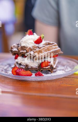Deliziosi waffle al cioccolato serviti con panna e fragole fresche, Calw Cafehaeusle, Foresta Nera, Germania, Europa Foto Stock