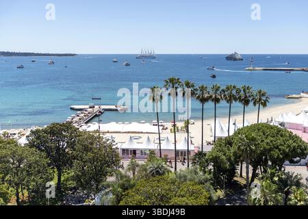 Cannes, Francia - 23 maggio 2024: Una nave da crociera ancorerà di fronte alla spiaggia sulla Promenade de la Croisette durante il 78° Cannes International Film F. Foto Stock
