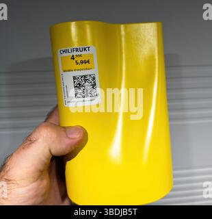 Parigi, Francia - 7 ottobre 2023: Primo piano di una mano che regge un vaso giallo CHILIFRUKT con superficie lucida e mostra il prezzo del modello con un pr ridotto Foto Stock