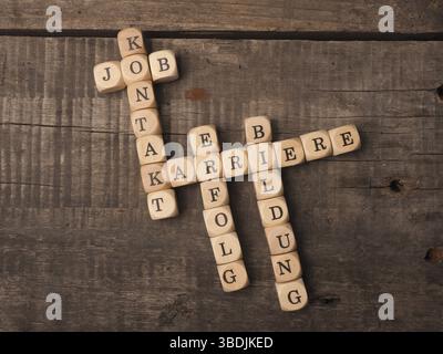 In tedesco il concetto di carriera con il cruciverba carriera, istruzione, lavoro, il successo e il contatto su una tavola in legno rustico Foto Stock