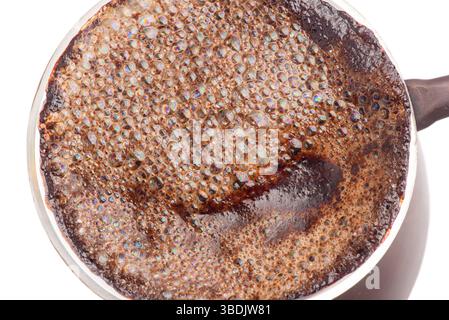 Caffè macinato appena estratto in un isolato di Turk in rame su sfondo bianco Foto Stock