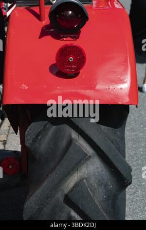 Svizzera - 23 giugno 2019: Primo piano della ruota posteriore e del parafango di un classico trattore rosso all'Heidiland Classic Car Meet Foto Stock