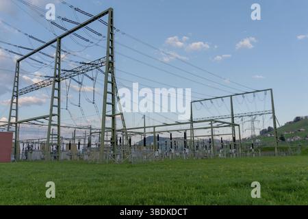 Vista orizzontale di una grande potenza ad alta tensione in stazione le colline della Svizzera fornisce il backcountry con elettricità Foto Stock