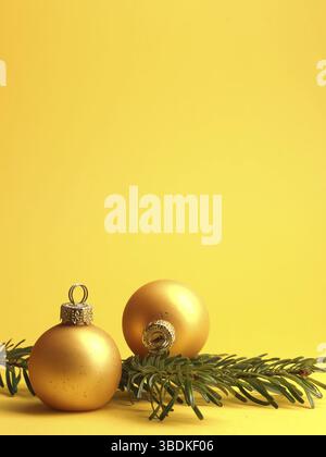 Due baubles d'oro vintage di Natale su sfondo giallo con spazio per il tuo testo o immagine, concetto di vacanza stagionale Foto Stock