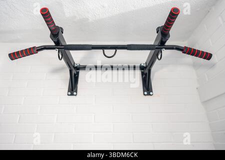 Dispositivo ancorato alla parete per fare esercizi di pull-up e migliorare le condizioni fisiche e muscolari. Foto Stock