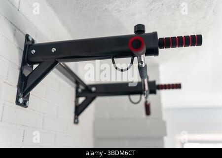 Dispositivo ancorato alla parete per fare esercizi di pull-up e migliorare le condizioni fisiche e muscolari. Foto Stock