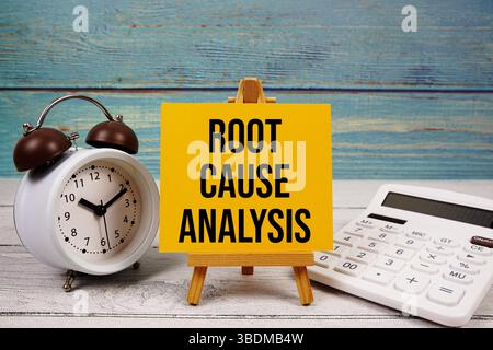 Testo RCA (root cause Analysis) scritto su scheda cartacea con calcolatrice e sveglia su sfondo in legno Foto Stock