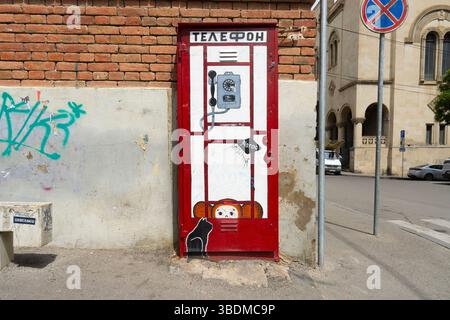 Tbilisi, Georgia. 16 maggio 2025. Una cabina telefonica dipinta su una vecchia porta in un edificio nel centro della città Foto Stock