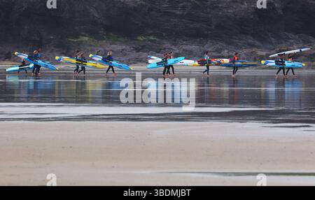 Polzeath, Cornovaglia, Regno Unito. 25 maggio 2025. Meteo nel Regno Unito: Naviga! Appassionati di surf su una spiaggia umida e sovrastata di Polzeath, in Cornovaglia. Crediti: Nidpor/Alamy Live News Foto Stock