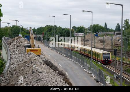 Berlino, Germania. 25 maggio 2025. Un escavatore si trova tra cumuli di macerie nel cantiere sulla superstrada A100 vicino all'ICC dopo la demolizione del ponte Ringbahn. Circa 1,9 chilometri di superstrada, compresi gli svincoli e diversi ponti, devono essere rinnovati presso l'incrocio Funkturm, che è stato costruito negli anni '1960 È inoltre prevista una nuova giunzione di Messedamm. Credito: Soeren Stache/dpa/ZB/dpa/Alamy Live News Foto Stock