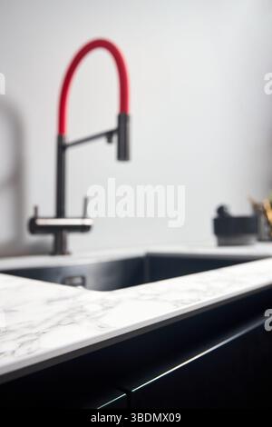 Foto ravvicinata di un moderno piano di lavoro da cucina realizzato in laminato compatto ad alta pressione con messa a fuoco selettiva HPL, con sfondo sfocato con b quadrato Foto Stock