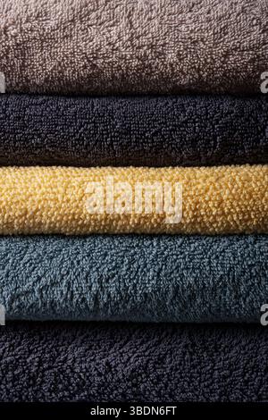 Un set di asciugamani in spugna colorati. Una pila di asciugamani piegati in modo splendido. Comfort di casa. Foto Stock