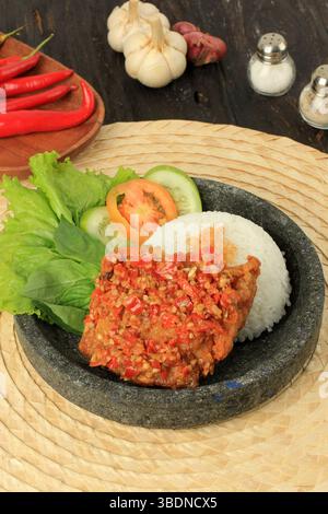 Ayam Geprek è popolare Street Food in Indonesia. Prodotto da pollo croccante schiacciato in Sambal Bawang Foto Stock