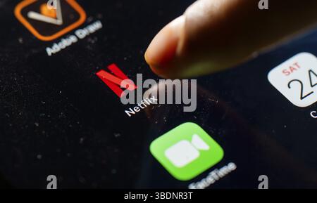 In questa foto, una persona tocca l'icona dell'app Netflix su un tablet il 24 maggio 2025 a nuova Delhi, India, Asia Foto Stock